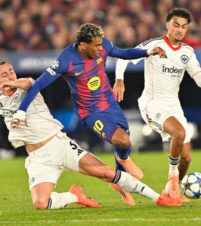 Frankfurts Arthur Theate grätscht im Zweikampf Lamine Yamal mitsamt dem Ball um.