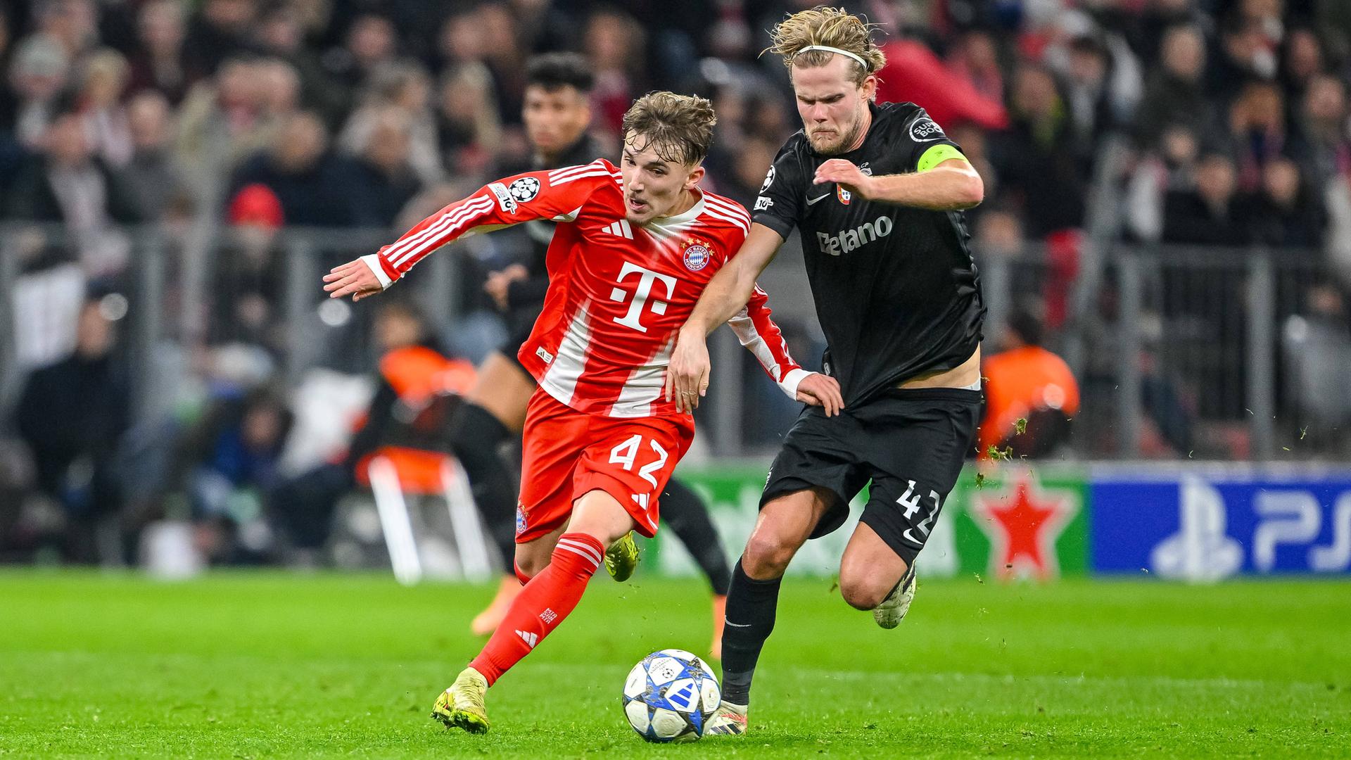 Im Championsleaguespiel des FC Bayern München gegen Sporting Lissabon kämpfen Bayerns Lennart Karl und Sportings Morteb Hjulmand um den Ball.