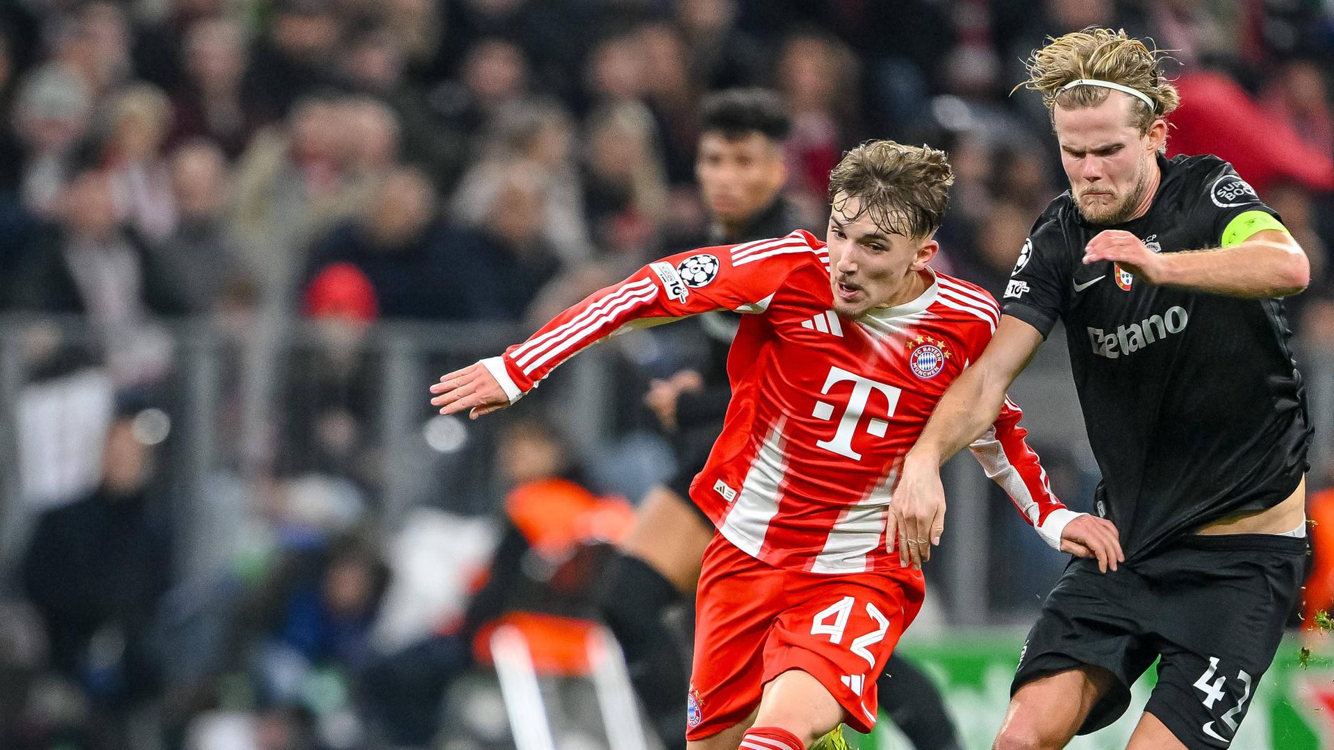 Im Championsleaguespiel des FC Bayern München gegen Sporting Lissabon kämpfen Bayerns Lennart Karl und Sportings Morten Hjulmand um den Ball.