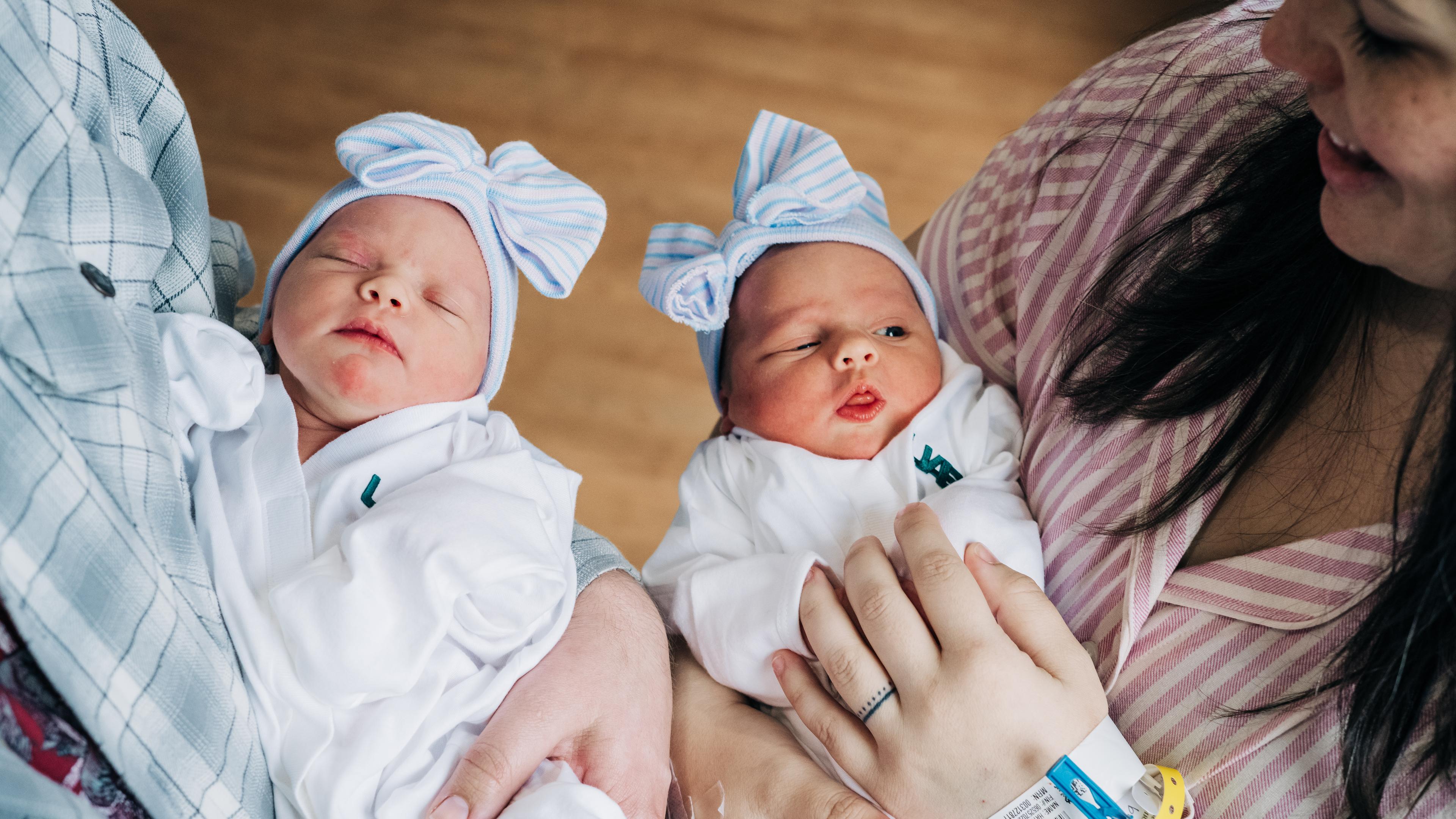 Zwillinge werden nach der Geburt von ihren Müttern gehalten. 