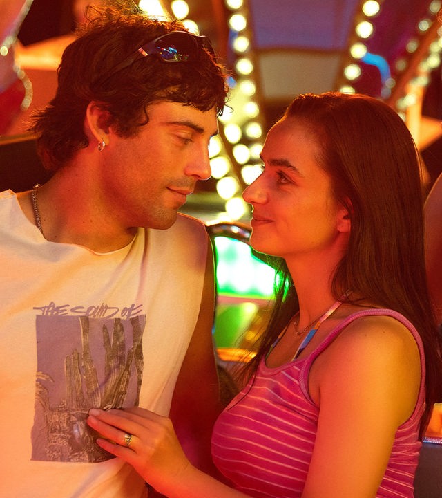 "Zwischen uns die Nacht": Erich (Aaron Altaras) und Marie (Laura Balzer) sehen sich in die Augen während Rebecca (Bea Brocks) und Haro (Paul Boche) in die Kamera sehen. Im Hintergrund leuchtet ein Fahrgeschäft bei Nacht.