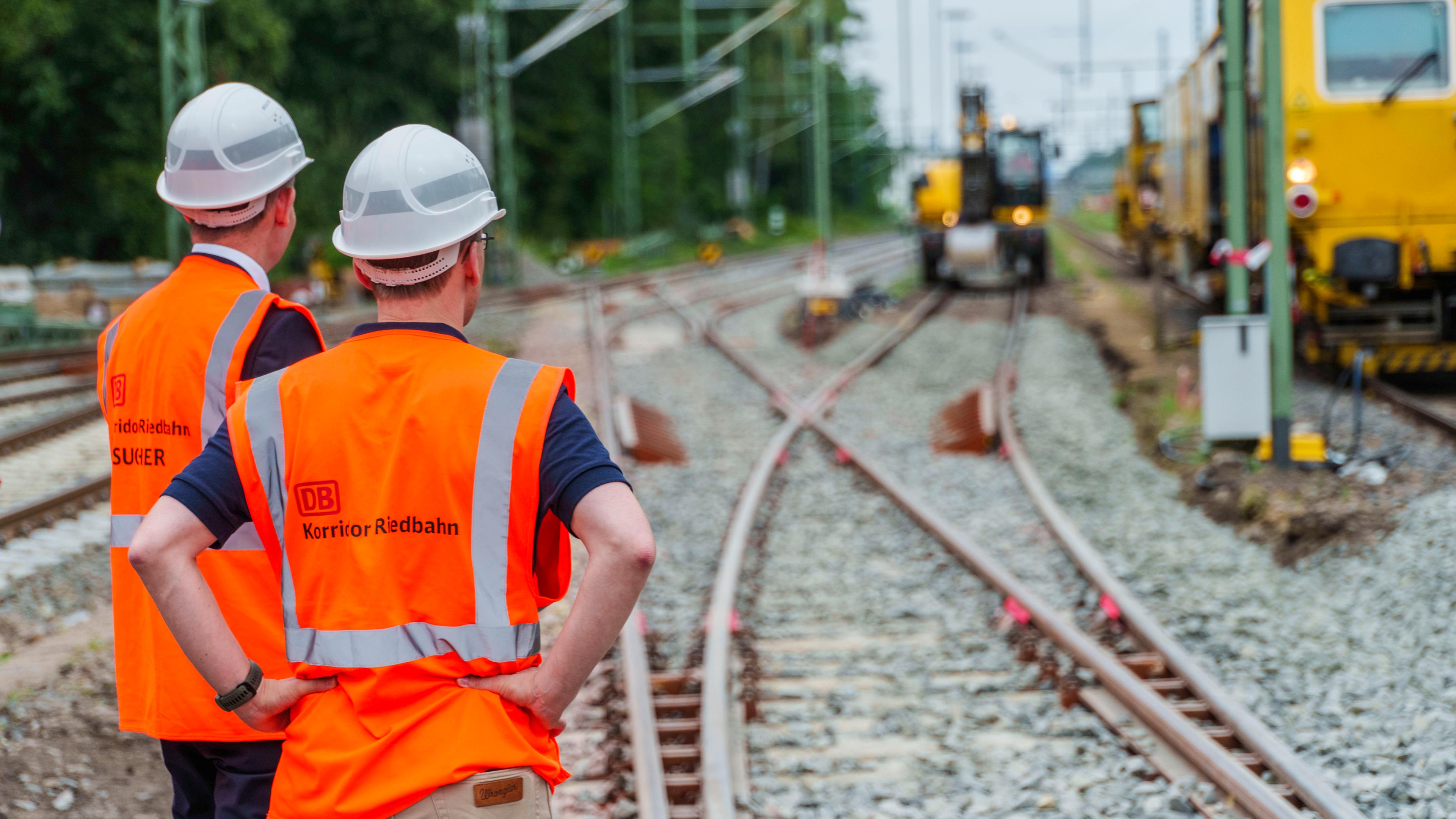 Hessen, Mörfelden-Walldorf: Teilnehmer des Presserundgangs schauen auf die Baustelle im Abschnitt am Bahnhof Mörfelden/Walldorf. 