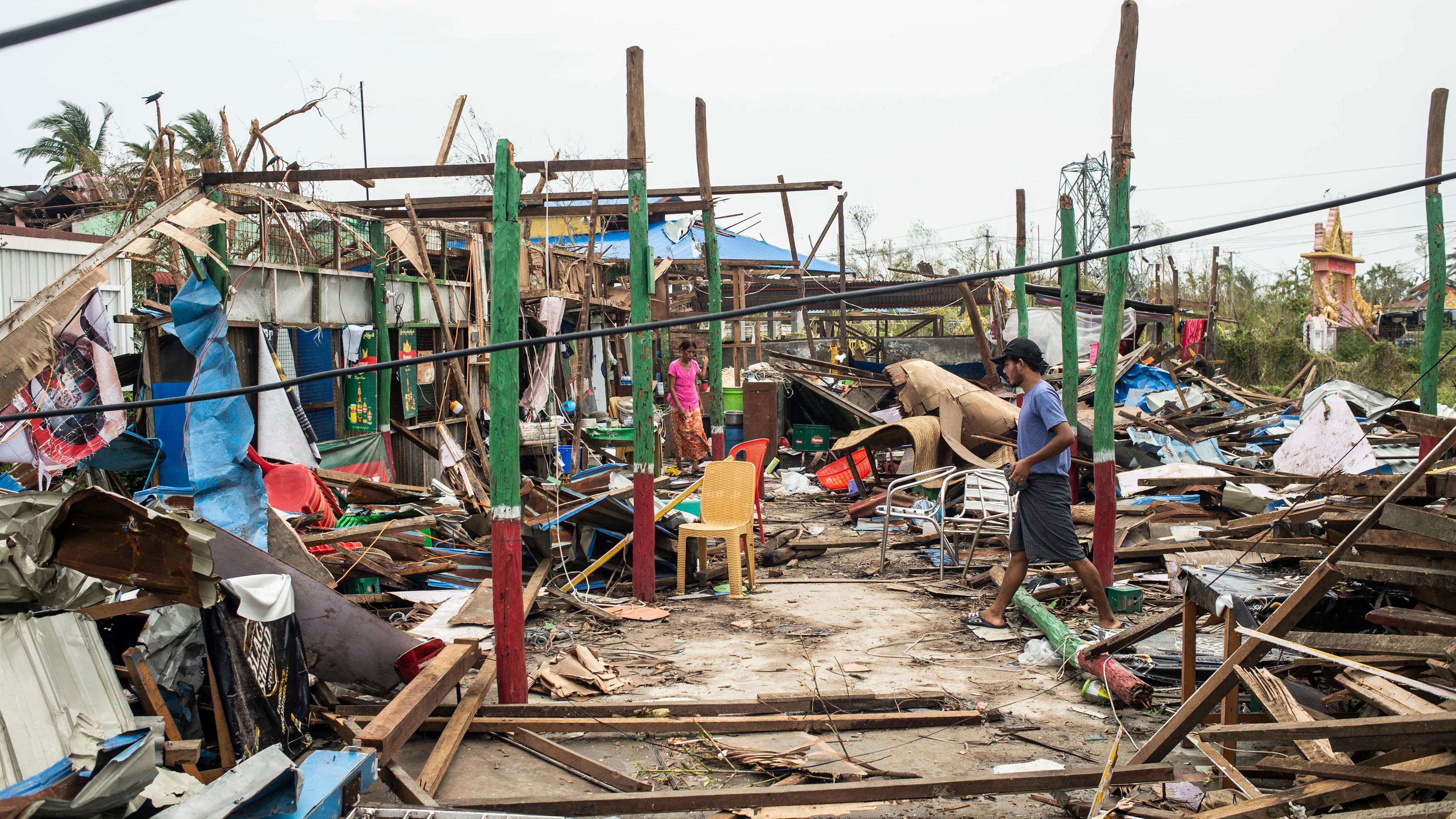 Myanmar, Sittwe: Anwohner gehen nach dem Zyklon "Mocha" an beschädigten Gebäuden.